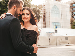 Beautiful fashion woman and her handsome boyfriend in suit. Sexy smiling brunette model in black...