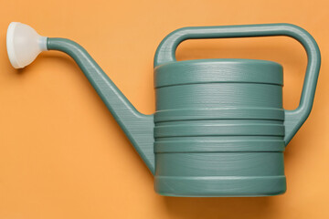 Watering can on color background