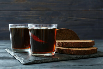 Glasses of fresh kvass on dark wooden background