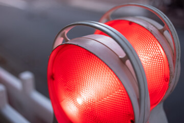 Closeup of red warning lights glowing in the dark at a construction site 