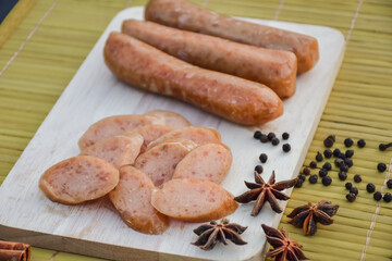 Sausage Or Guan Chiang and Herbs on the board, serving good beer snacks on a dark background.