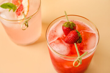 Glasses of tasty grapefruit and strawberry margarita on color background