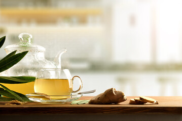Ginger infusion on wooden kitchen bench with ginger root front
