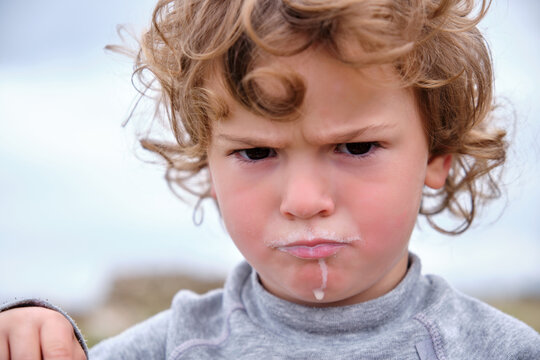 Portrait Of A Child With A Frown And A Milk-stained Mouth.