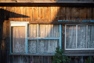 Facade of a vintage wooden building under the rays of the spring sun, sunset