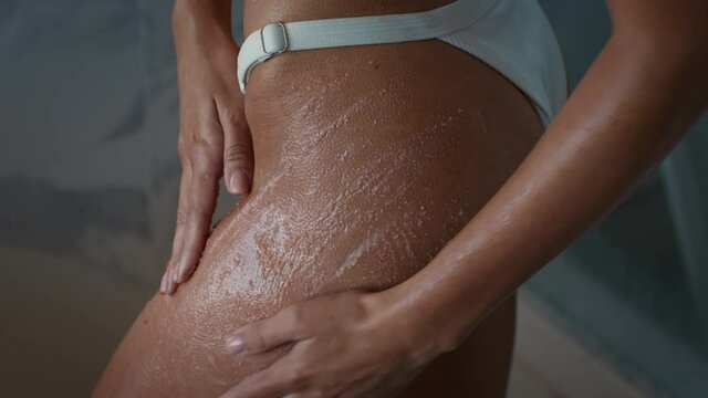 Unrecognizable Woman Applying Scrub On Hips Caring For Skin Indoor