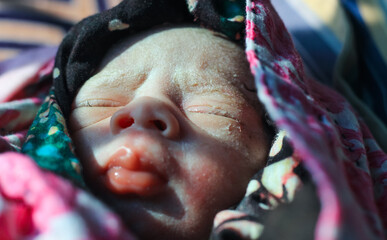 Beautiful baby boy a few seconds after the birth. Baby after birth.