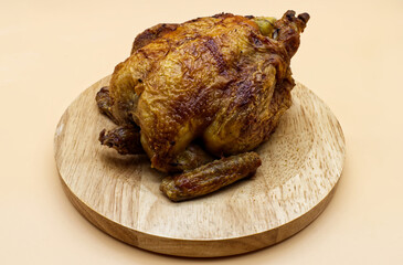 Whole roasted chicken isolated on wooden dish