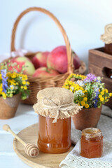 Jars with honey and bouquet of wild flowers on the table.