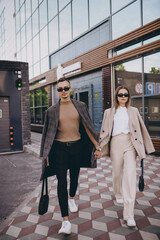 Fototapeta na wymiar a couple of stylish young people in sunglasses are walking the city streets