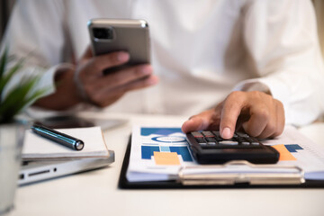 Fototapeta premium Male are calculating income-expenditure and analyzing real estate investment data at office.