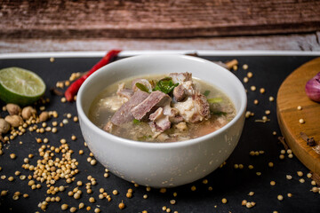 Indonesian goat soup with tomatoes, celery, green onions, ginger, hazelnut and lime leaves