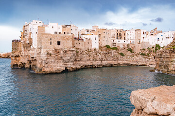 Fototapeta na wymiar Polignano a Mare. Town on the cliffs, Puglia region, Italy, Europe. Traveling concept background with old traditional houses, dramatic sky, Mediterranean Sea