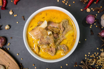 Close Up Indonesian Mutton Curry with red sauces on bowl and spices. One of the aqiqah menus
