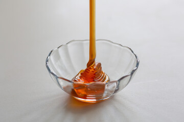 fresh natural honey is poured into a bowl