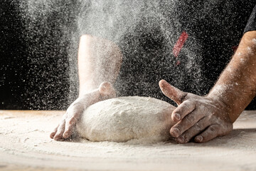 Male hands making dough for pizza. Beautiful and strong men's hands knead the dough make bread, pasta or pizza