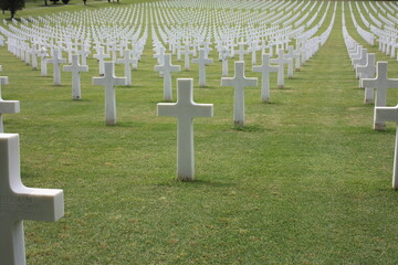 shot of the american military cemetery of the second world war with the crosses of the dead soldiers resting under a beautiful green lawn