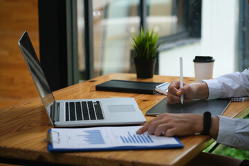 Closed up with businesswoman using stylus pen writing on the tablet and pointing on the document...