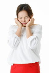 Isolated studio shot of Asian sad disappointment unhappy stressed depressed female model in casual long sleeve shirt standing holding hands on frown scowling face in front of white background