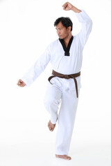 Isolated portrait studio shot of Asian middle aged male tae kwan do karate judo sport athlete in uniform with brown belt standing look at camera posing strong gesture in front of white background