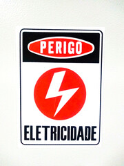 Electricity danger sign, written in Portuguese, on white background. 