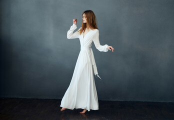 Fototapeta na wymiar elegant woman in white dress dark background posing performance