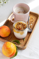 breakfast in bed with yoghurt, cappuccino and fruit