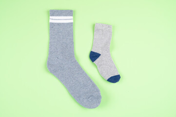 Adult and children's socks on a pistachio-colored background