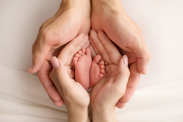 the legs of the child in the arms of our mother and father. feet of a newborn baby. little baby...