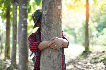 Concept : Love nature. Male botanist is hugging tree in forest.     