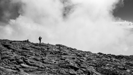 femme qui fait des photographies dans la brume dans la nature, au volcan le piton de la Fournaise...