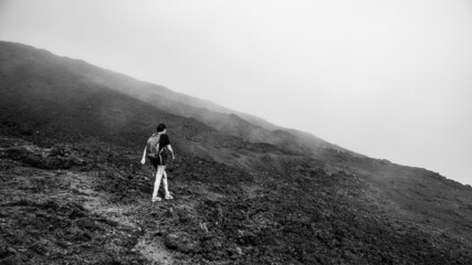 femme marche dans la brume dans la nature, au volcan le piton de la Fournaise à la Réunion.