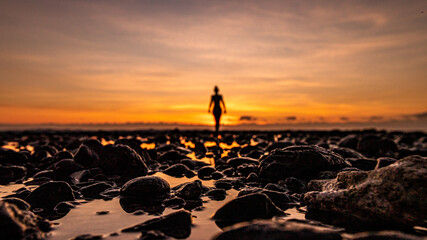 femme flou et de dos pendant un coucher de soleil en bord de met avec jolies couleurs sur l'ile de...