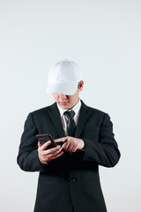 Portrait of a handsome Asian man in a black suit wearing a white hat on a white background. Concept of young businessman. with free space to copy