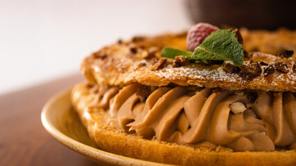 Gros plan sur un Paris Brest avec creme et framboise. 
