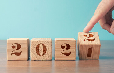 Flipping wooden cubes with the Year number 2021 and 2022, New Year concept