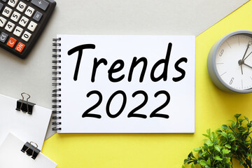 Trends for 2022. gray and yellow background. text on white notepad paper