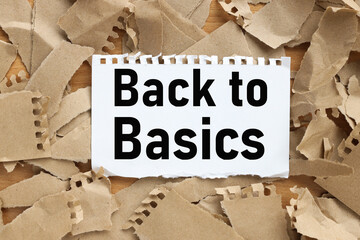 Back To Basics. text on white paper on torn kraft paper background