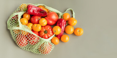 Food in green ecological bag. Vegetables yellow and red tomatoes and peppers in a grid.