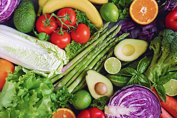 Healthy vegetables and fruits. Healthy food. The concept of healthy eating. Diet. Asparagus, broccoli, avocado, lime, parsley, basil, apple, banana, tomato, orange Food background. Vegetarian food.