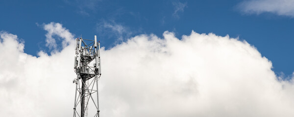 Bottom perspective pov of modern metal steel mobile 5g network wireless telecom tower against clear blue sky background on bright day. Microwave signal broadband equipment base line station mast