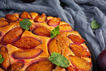 Delicious plum cake on wooden background. Homemade plum pie