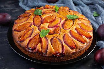 Delicious plum cake on wooden background. Homemade plum pie