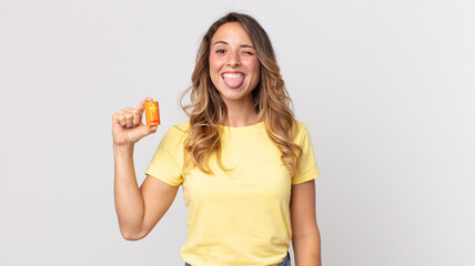 pretty thin woman with cheerful and rebellious attitude, joking and sticking tongue out and holding...