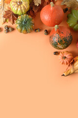 Festive vertical composition of pumpkins, colorful leaves on orange background with space for text. Thanksgiving Day and Halloween template.