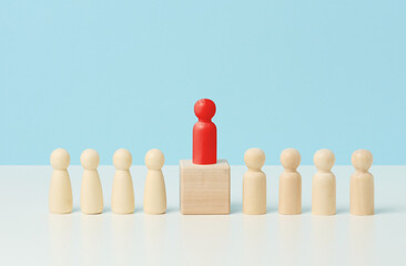 wooden little men on a white table, red stands on a wooden cube. Search for talented employees,...