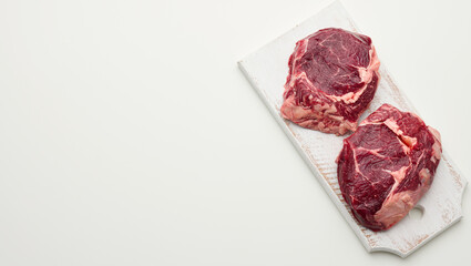 raw piece of beef ribeye on a white background, copy space