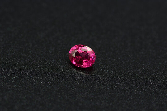 Natural earth mined unheated, untreated oval faceted rich red color loose tiny ruby gemstone setting for making jewelry from Winza, Tanzania. Black backgound. Gemology, mineralogy  theme.