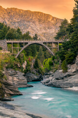 Edith Cavell Bridge surrounded by pine trees in New Zealand alpine region with beautiful sunset and...