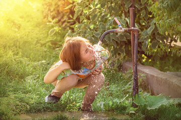 cute girl drinking water from the tap outdoors - obrazy, fototapety, plakaty